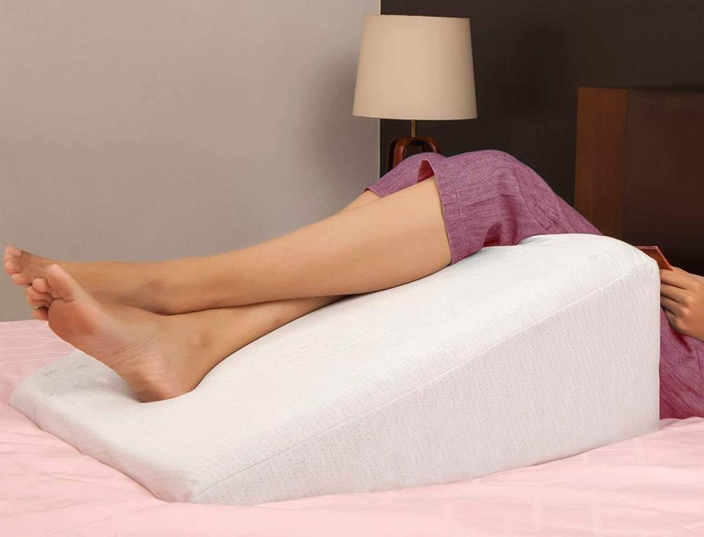 Couple sleeping quietly side by side using acid reflux wedge pillows to reduce snoring and heartburn