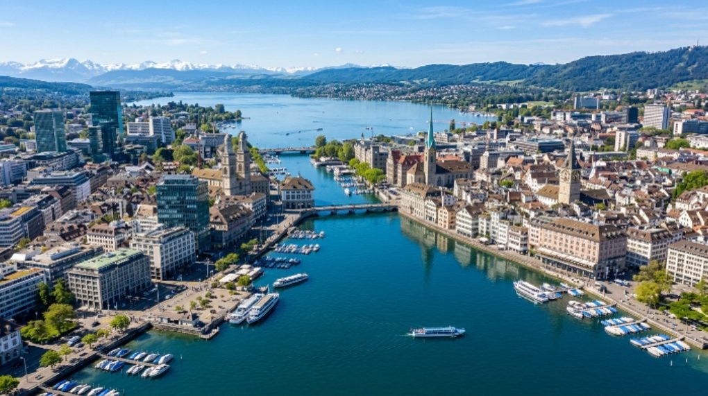 Aerial view of Zurich city skyline with Lake Zurich reflecting modern buildings on a clear day