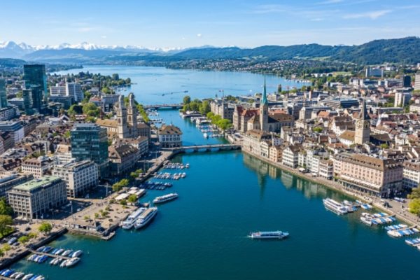 Aerial view of Zurich city skyline with Lake Zurich reflecting modern buildings on a clear day