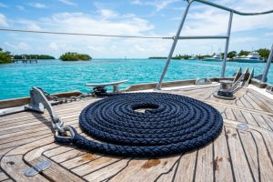 Coiled marine anchor rope on a boat deck overlooking Florida waters.