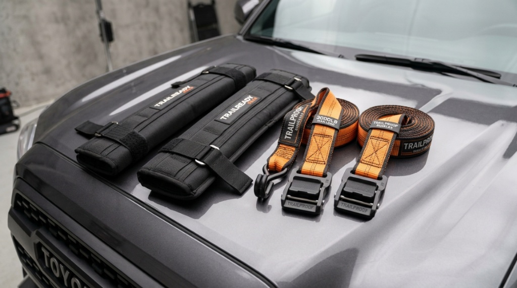 Soft rack pads and heavy-duty straps displayed on a truck hood.
