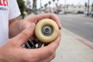Skateboard wheels being inspected for slow rotation